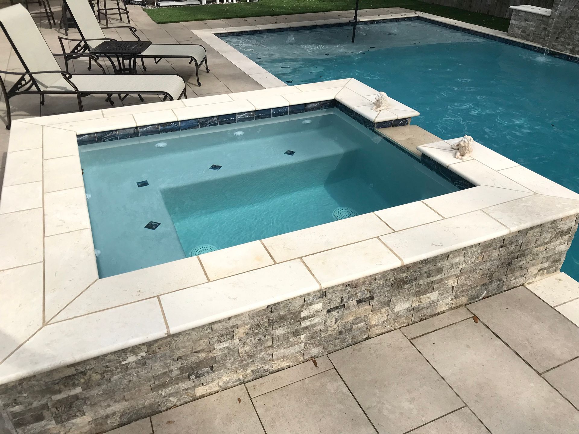 Raised spa connected to in-ground pool in backyard in Covington, LA