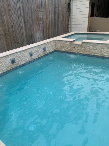 Backyard in-ground pool with attached hot tub in Gonzales, LA