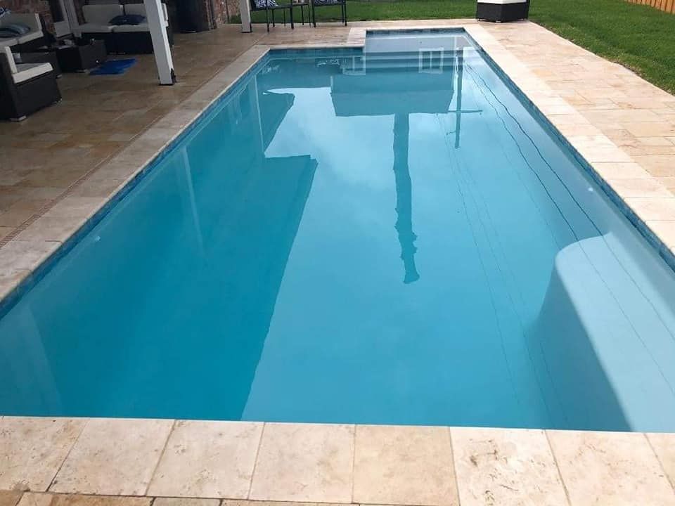 Rectangular in-ground pool with sleek patio and covered seating area in Harahan, LA