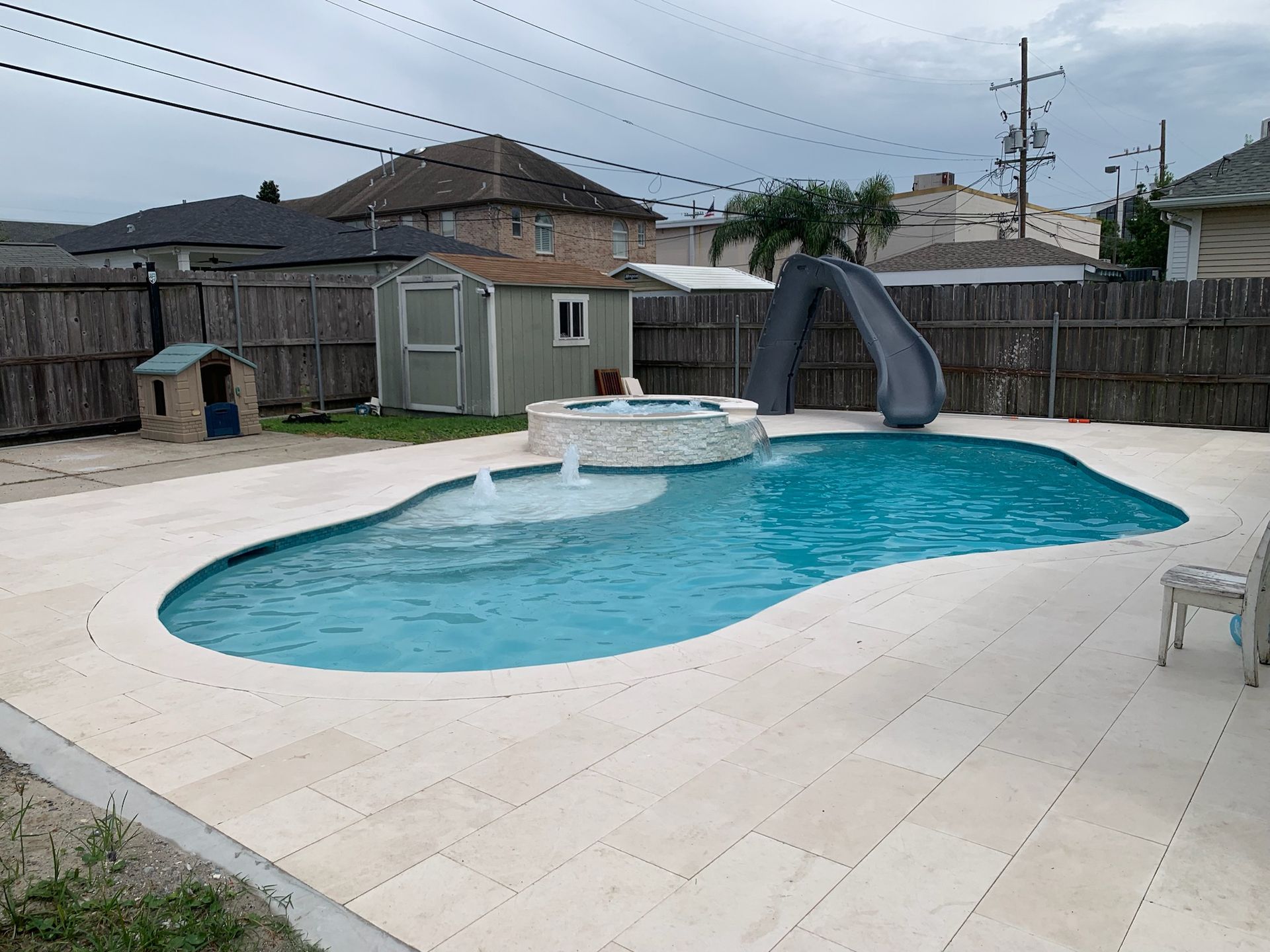 A large backyard pool with curved slide and open deck in Gonzales, LA