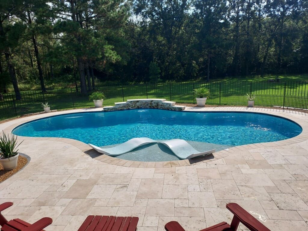 Circular in-ground pool with lounge chairs and stone patio in Slidell, LA