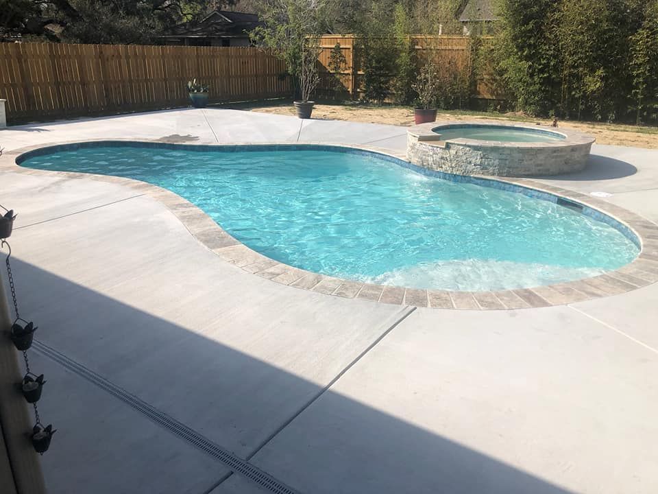 Backyard swimming pool with elevated spa and clean modern decking in River Ridge, LA