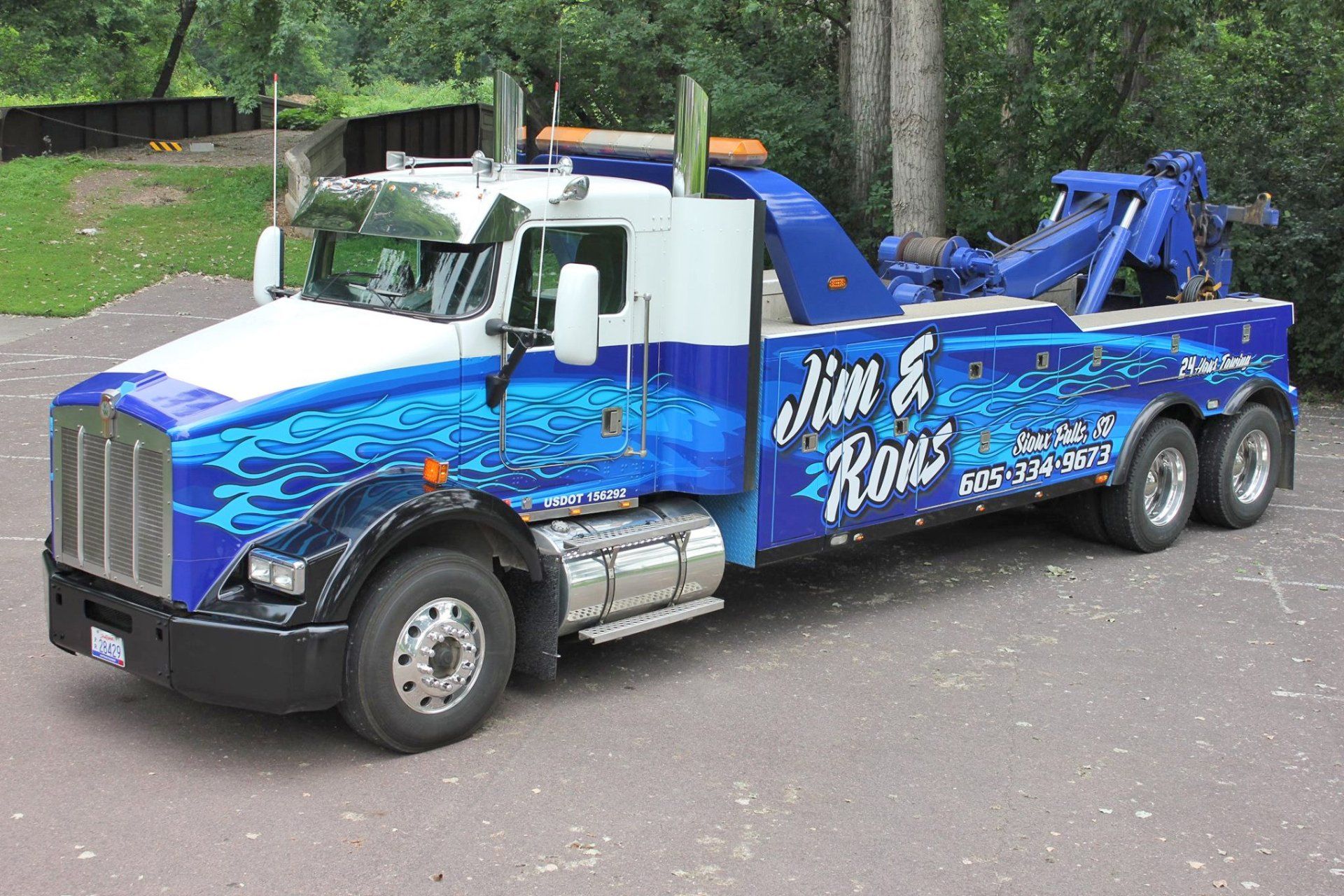 A blue and white tow truck with jim & ross written on the side