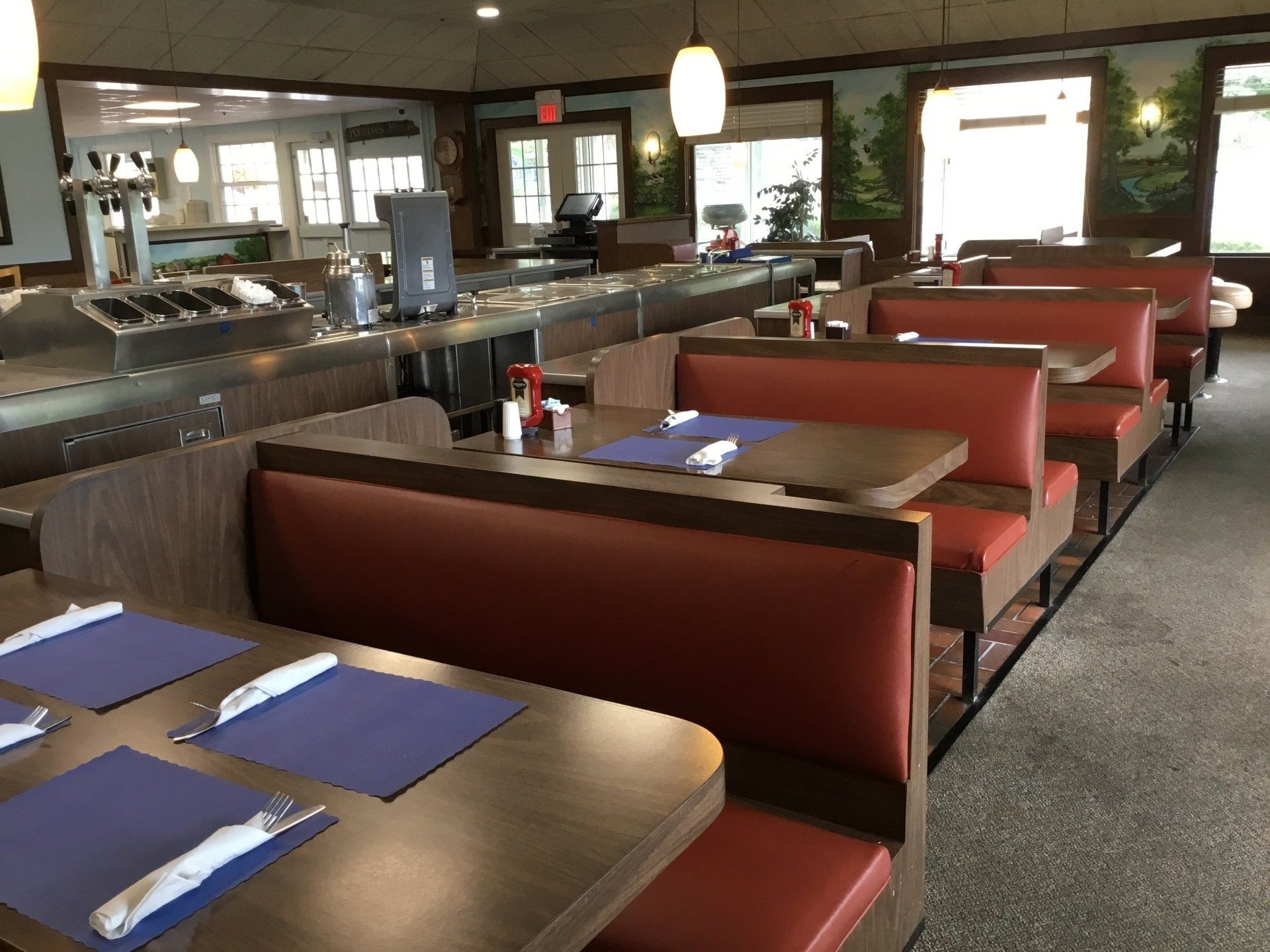 The inside of a diner with red booths and tables