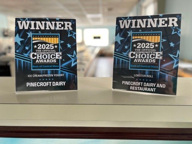 Two PineCrest Dairy 2025 Choice Awards winner plaques on a shelf in a blurred indoor setting