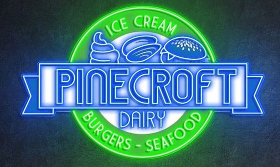 Pinecroft Dairy logo with neon blue and green lettering. Offers ice cream, burgers, and seafood.