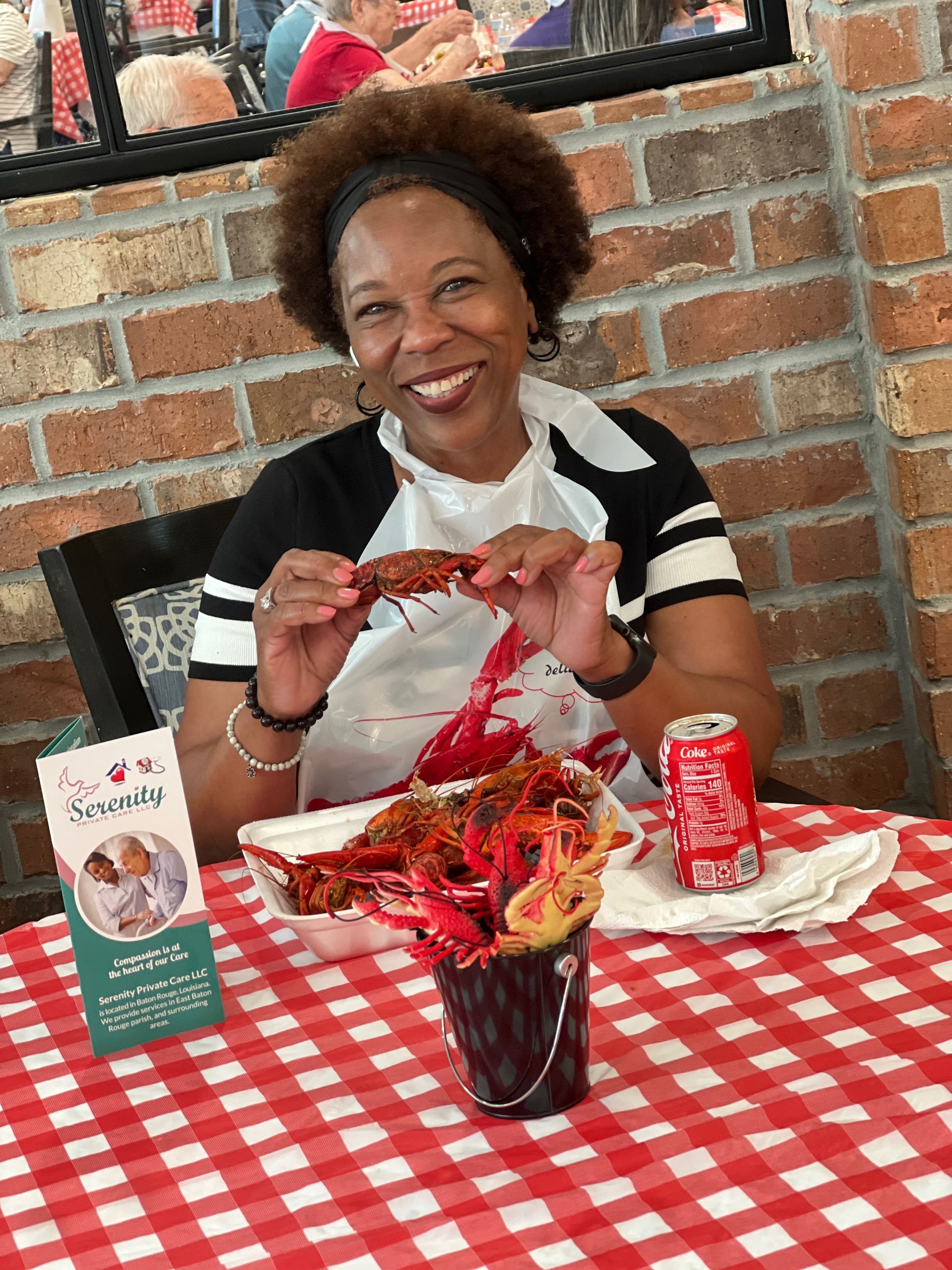 A woman is sitting at a table eating crawfish.