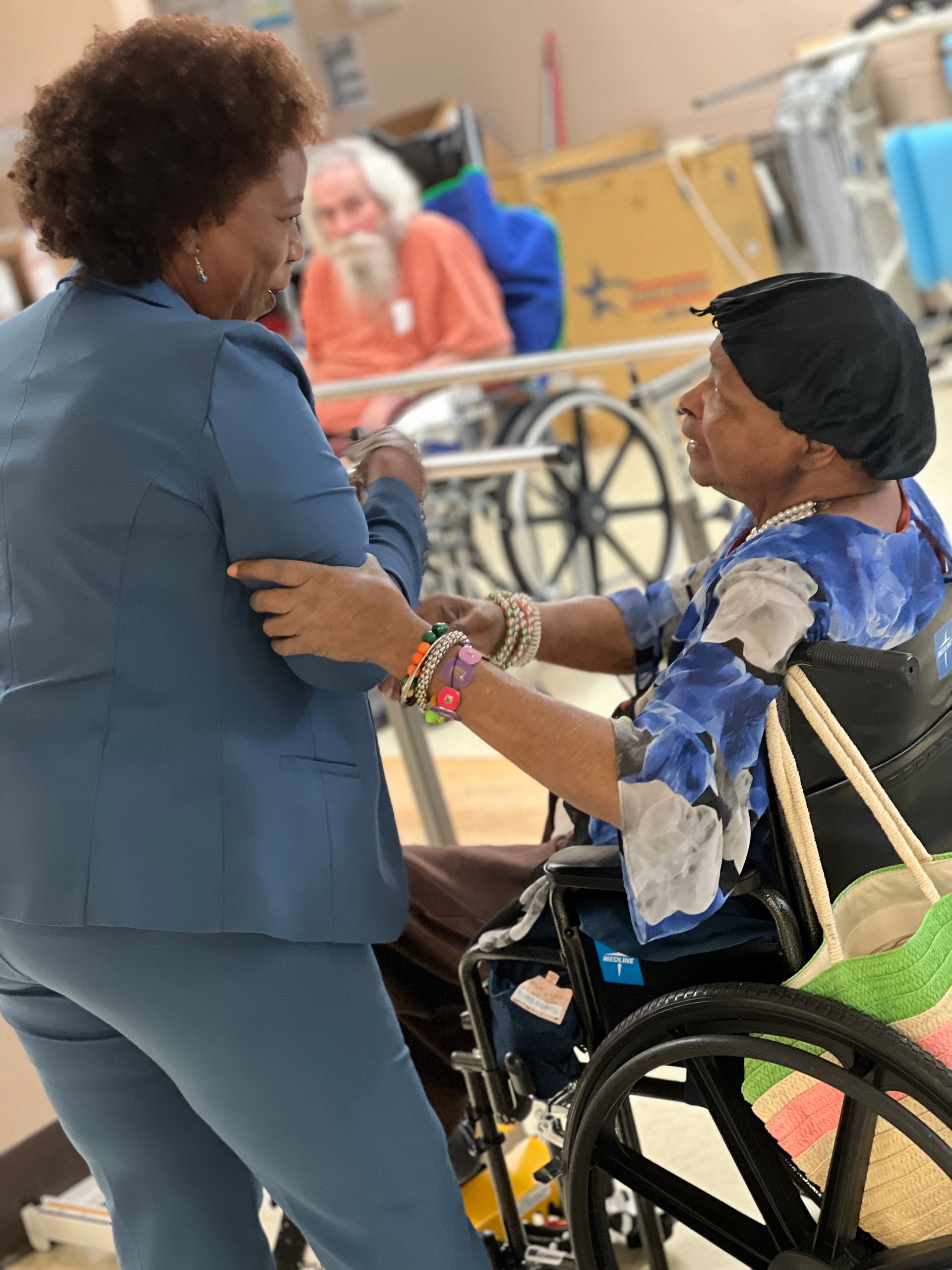 A woman in a wheelchair is dancing with another woman
