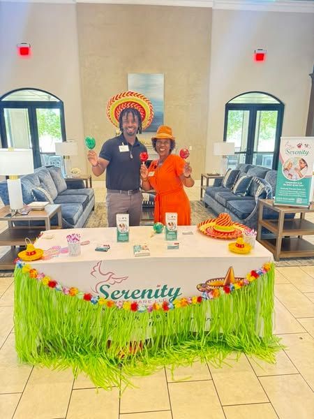 A man and a woman are standing in front of a table that says serenity.
