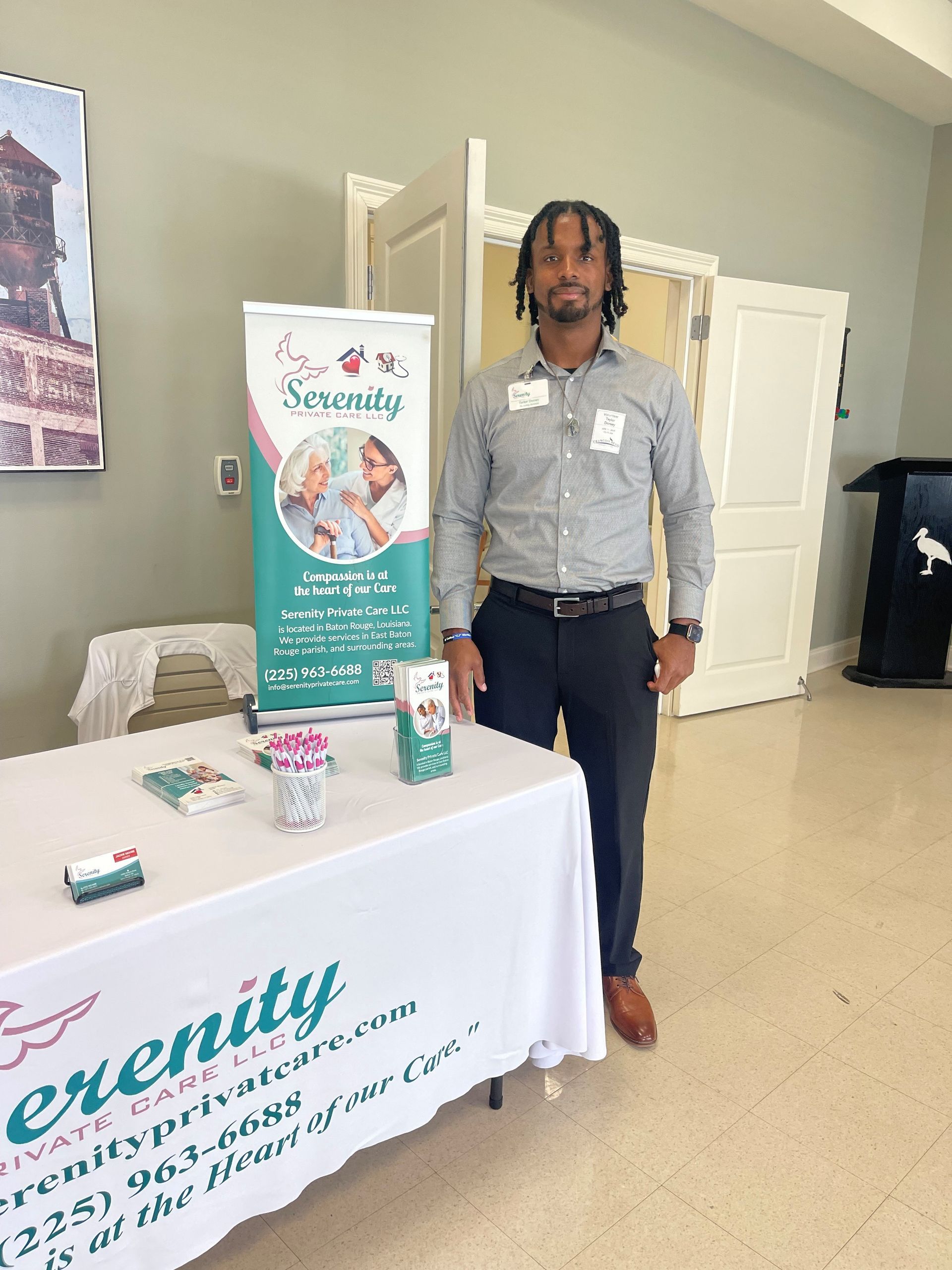 A man is standing in front of a table with a sign that says serenity on it.