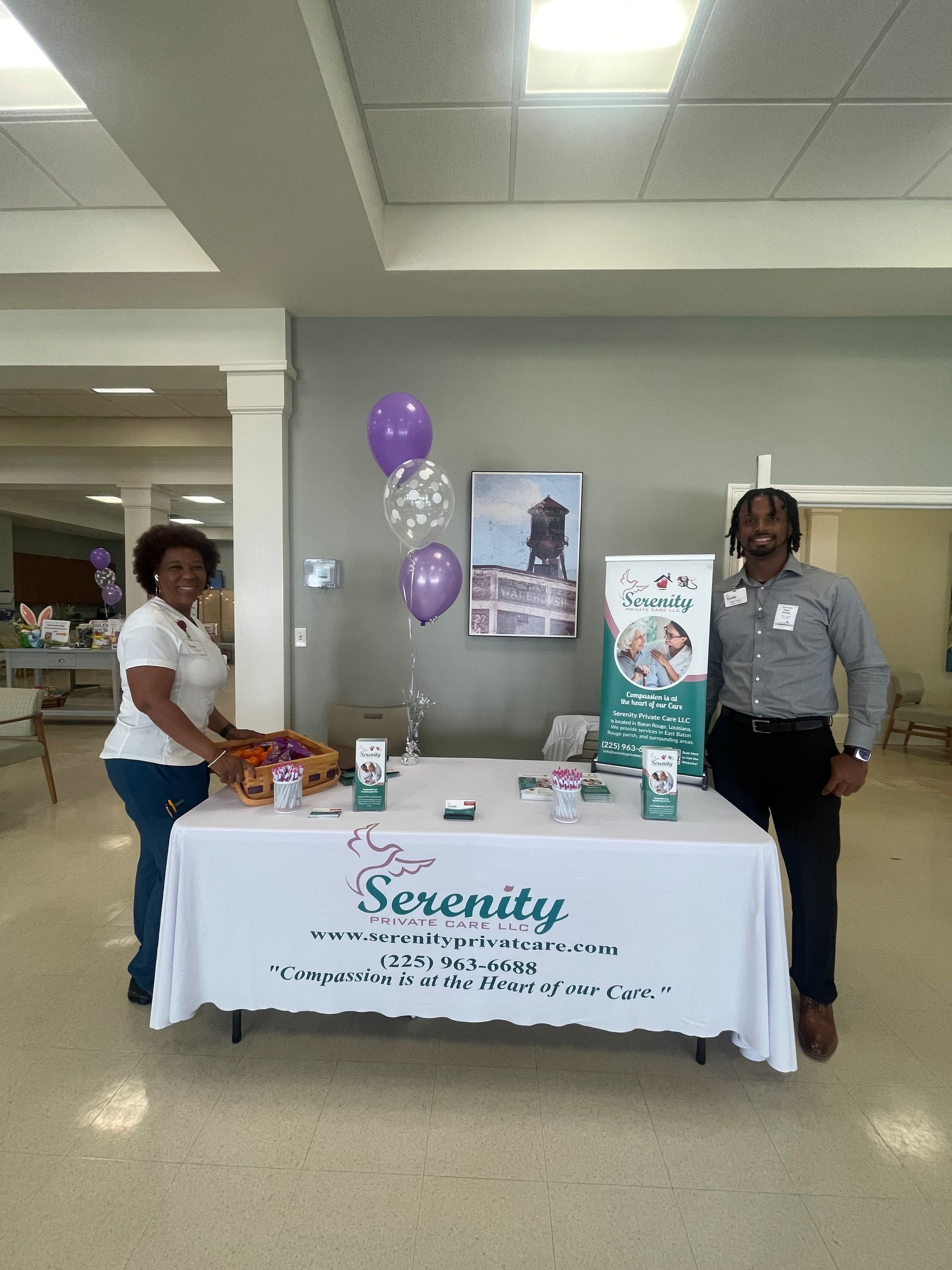 Two people are standing in front of a table that says serenity