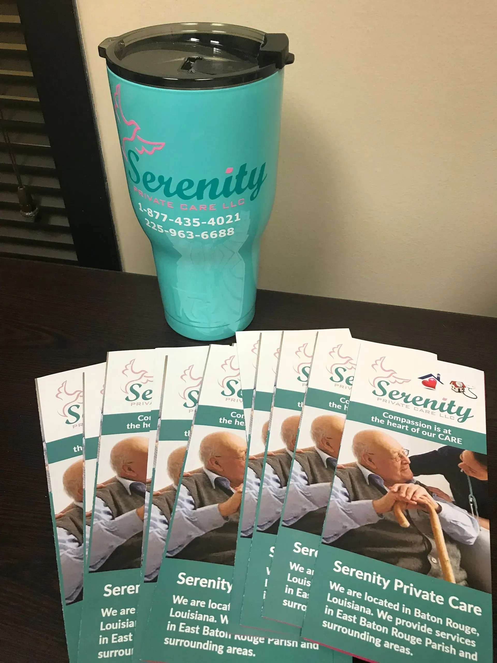 A stack of brochures next to a tumbler that says serenity.