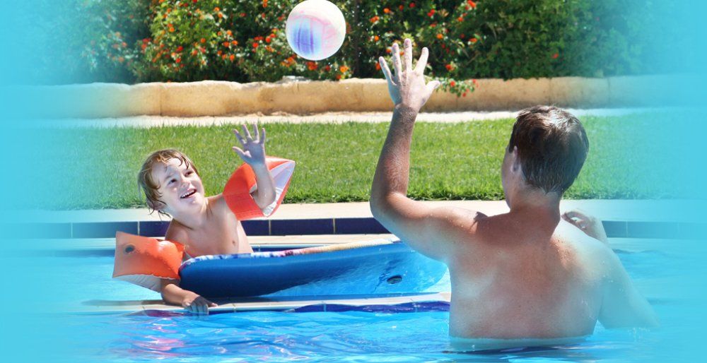 Father and son playing ball in a swimming pool