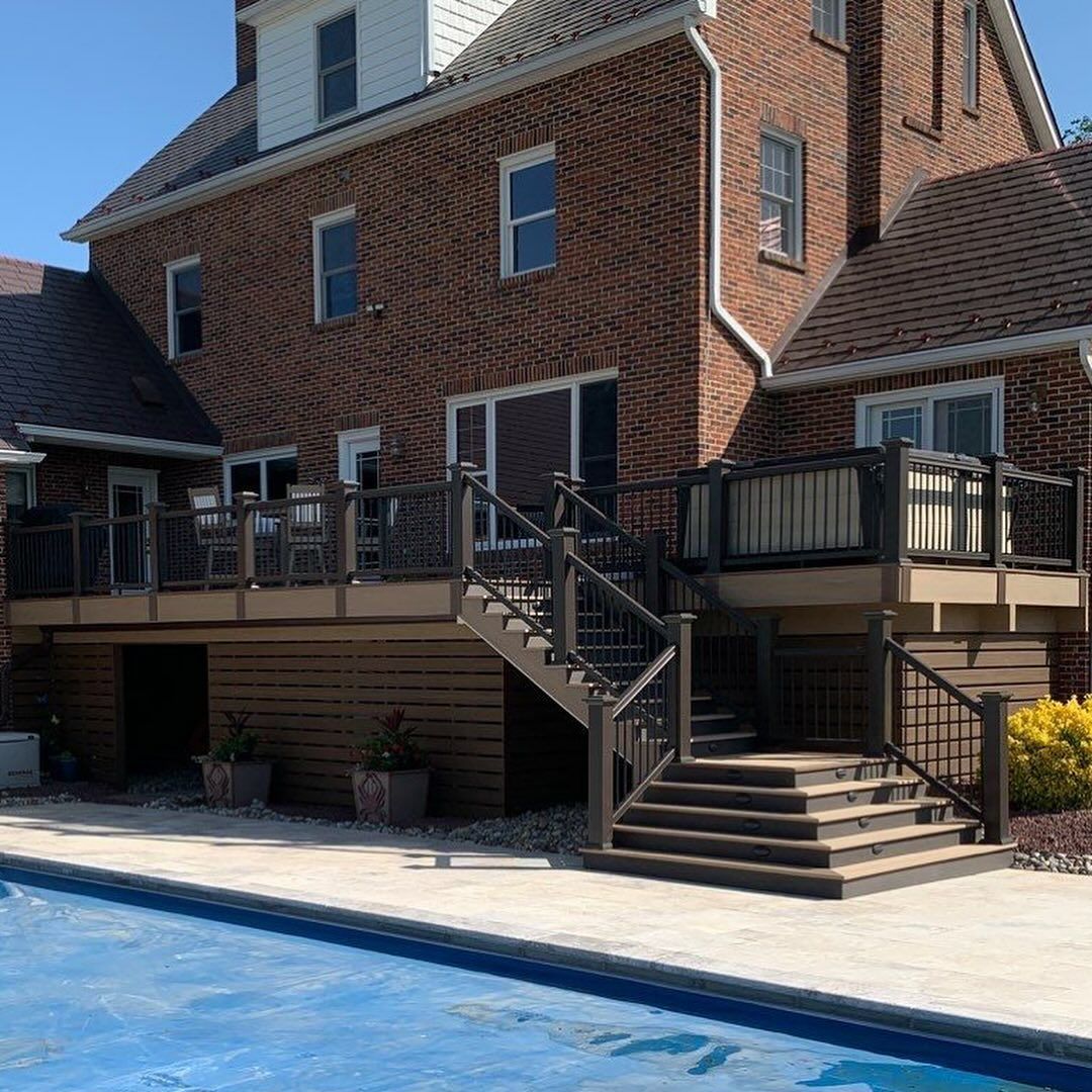 Brick house patio with stairs and railings beside a swimming pool