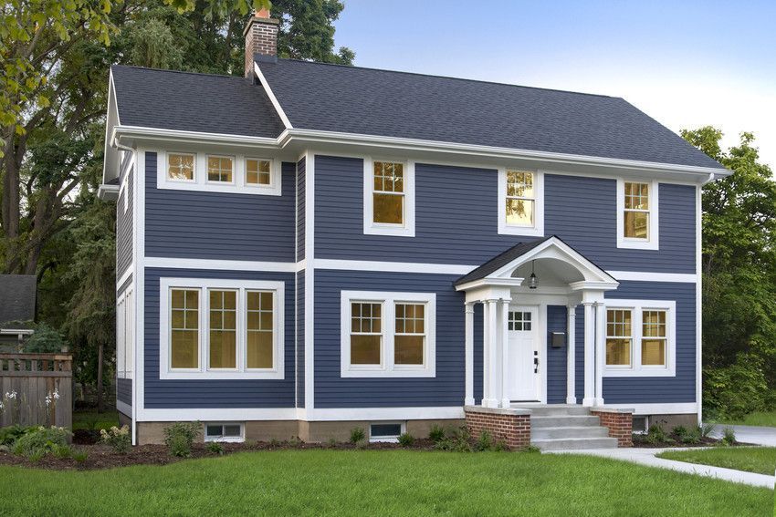 Blue two-story house with white trim, front porch, and neatly kept lawn