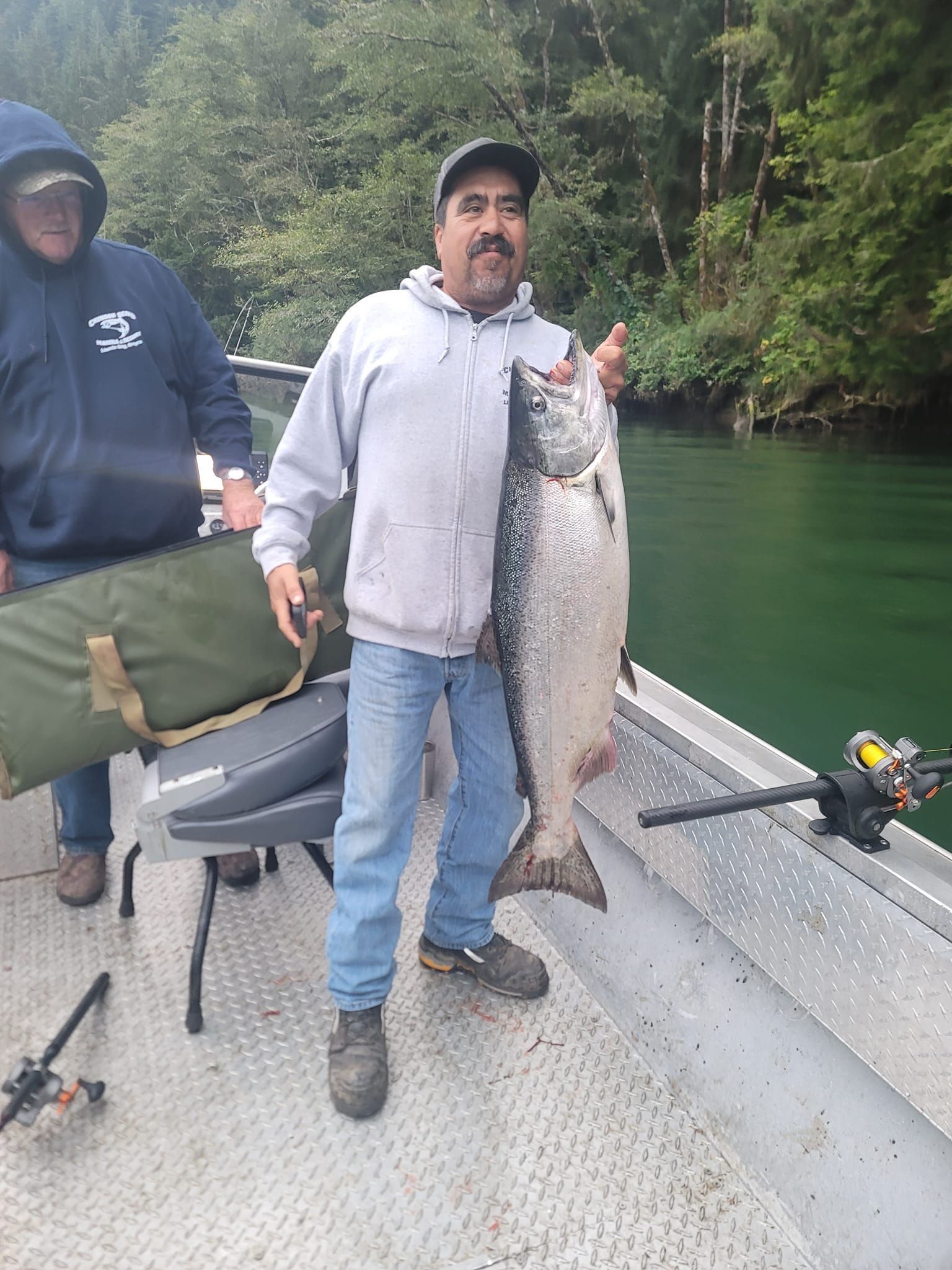A man is holding a large fish on a boat.