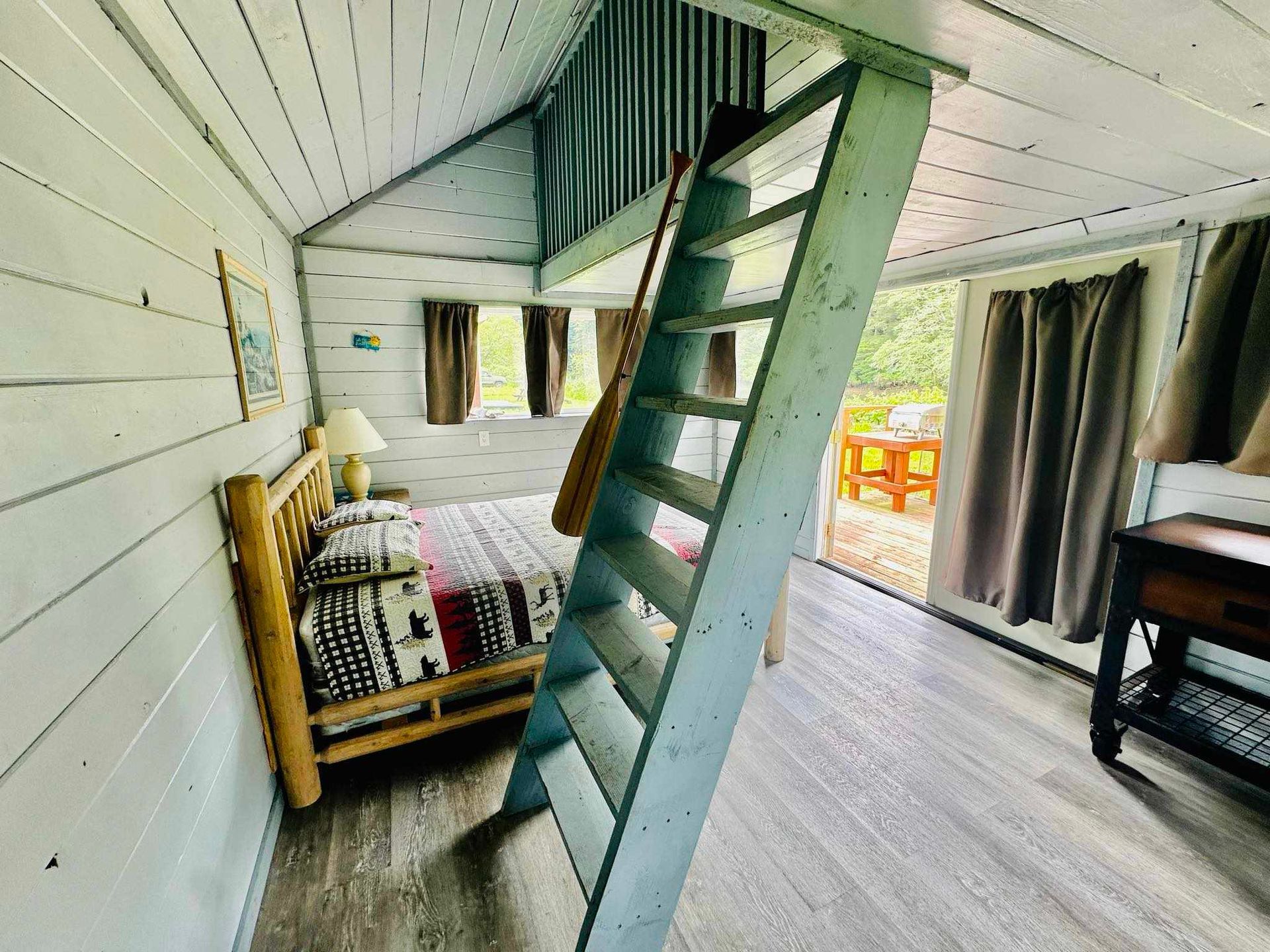 A bedroom with a bed and stairs leading to the second floor.