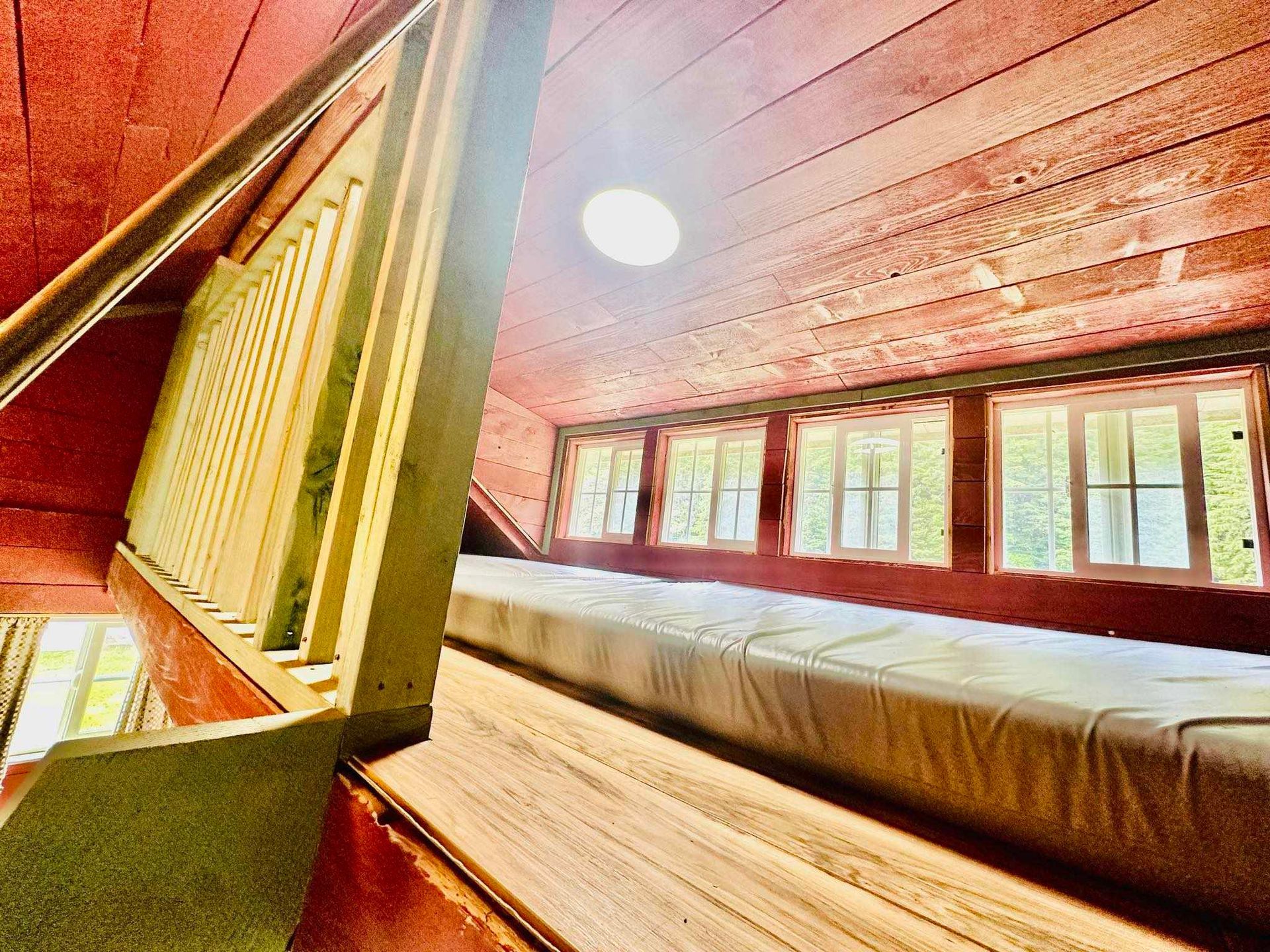 There is a bed in the attic of a house.