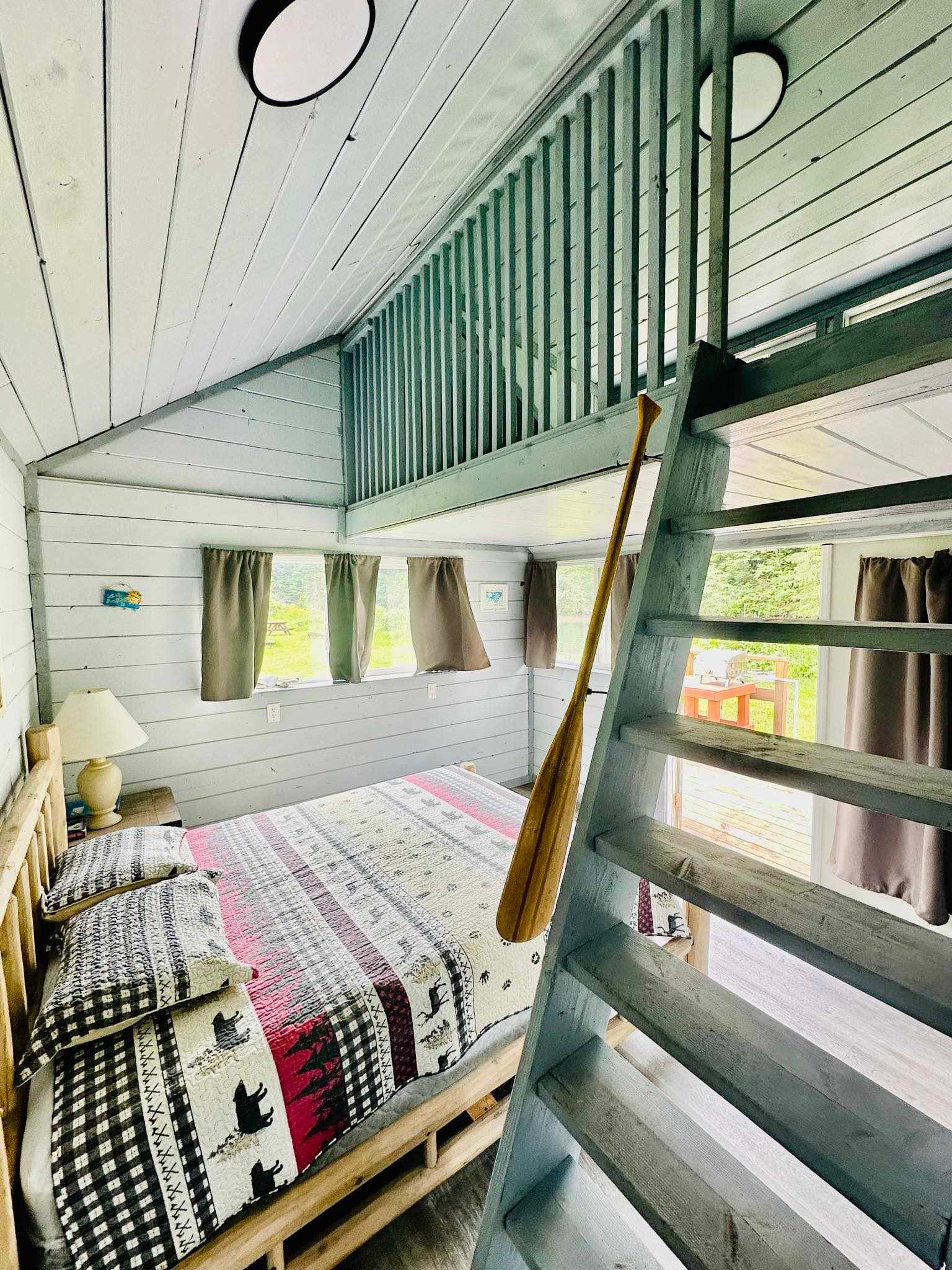 A bedroom with a bunk bed and stairs leading to the second floor.