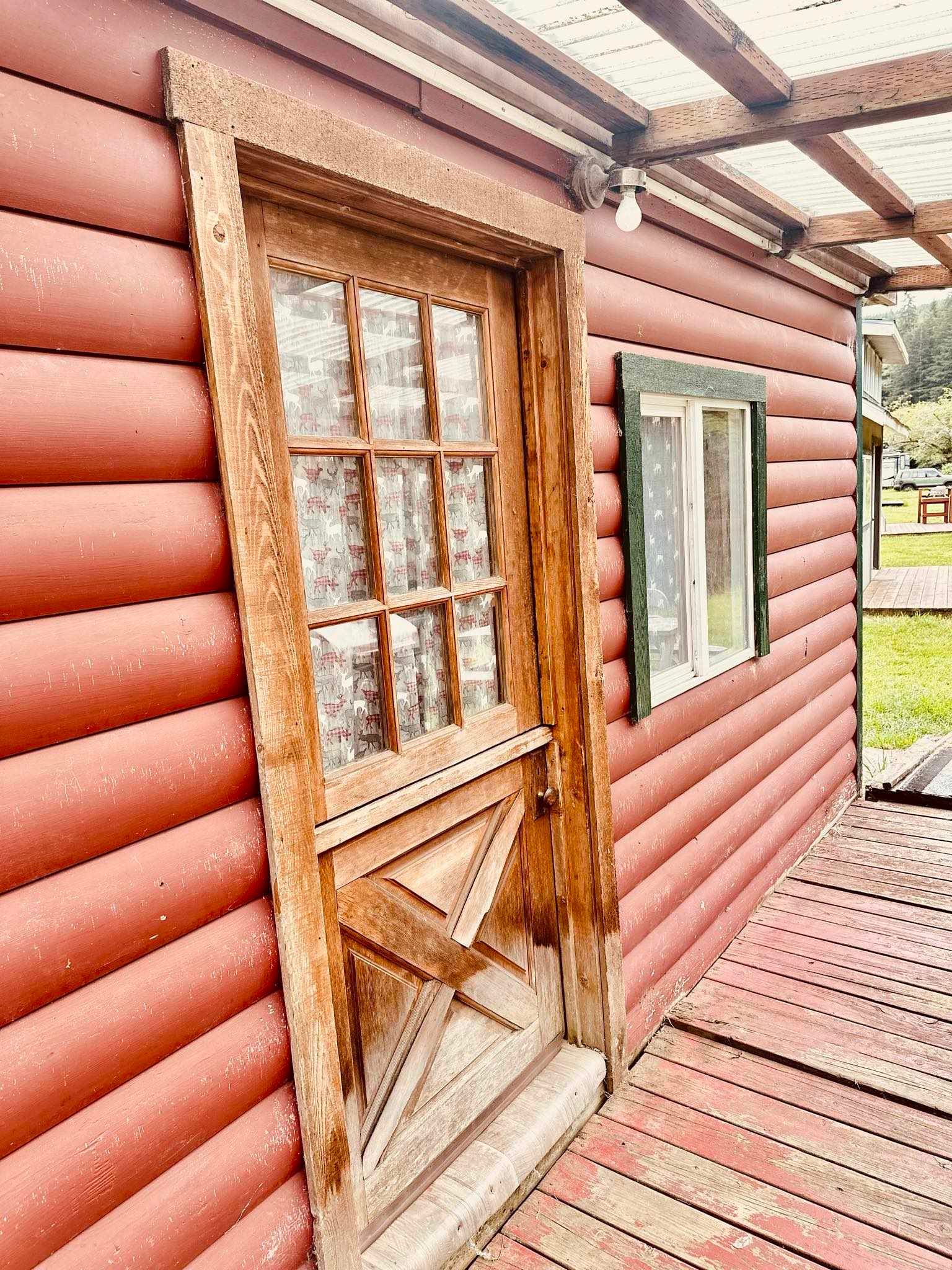 A log cabin with a wooden door and window.