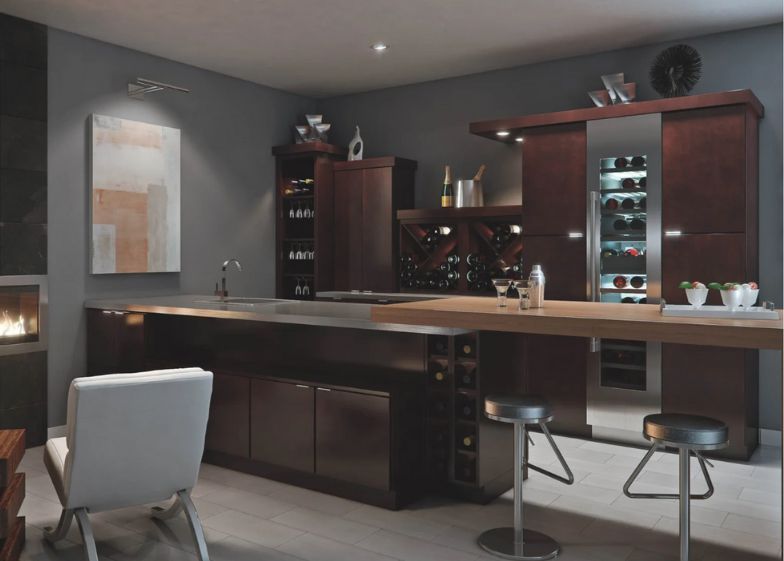 A modern home bar featuring dark wood cabinets, a wine fridge, bar stools, and a cozy fireplace in a gray-toned room.