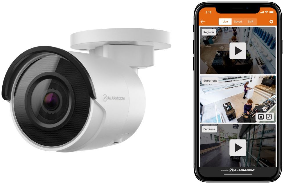 A security camera is sitting next to a smart phone.
