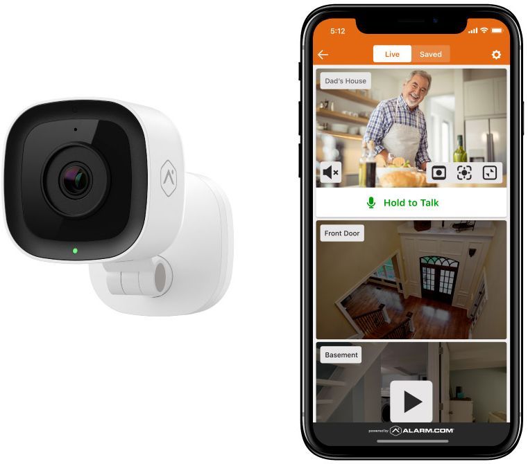 A security camera is sitting next to a smart phone.