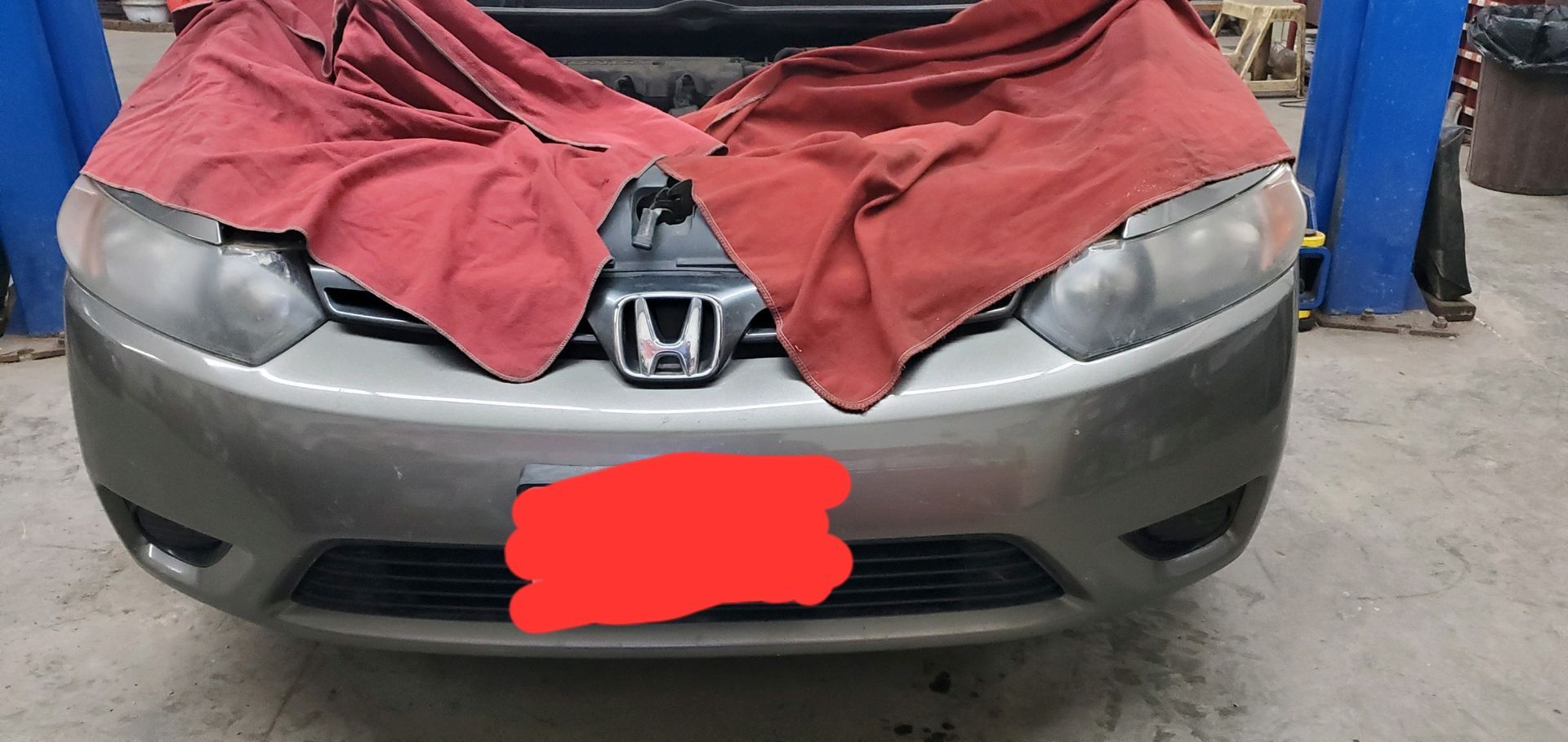 a silver honda car with a red towel on the hood