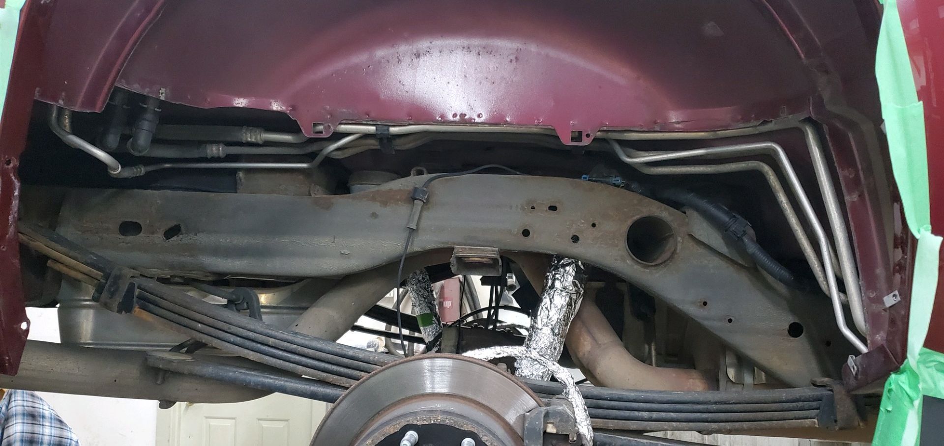 the underside of a red truck with a green tape covering it