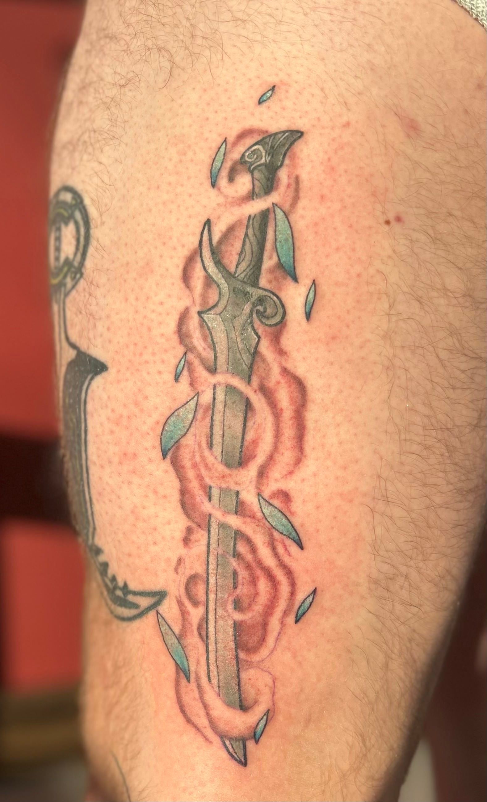 A tattoo of a sword with flames