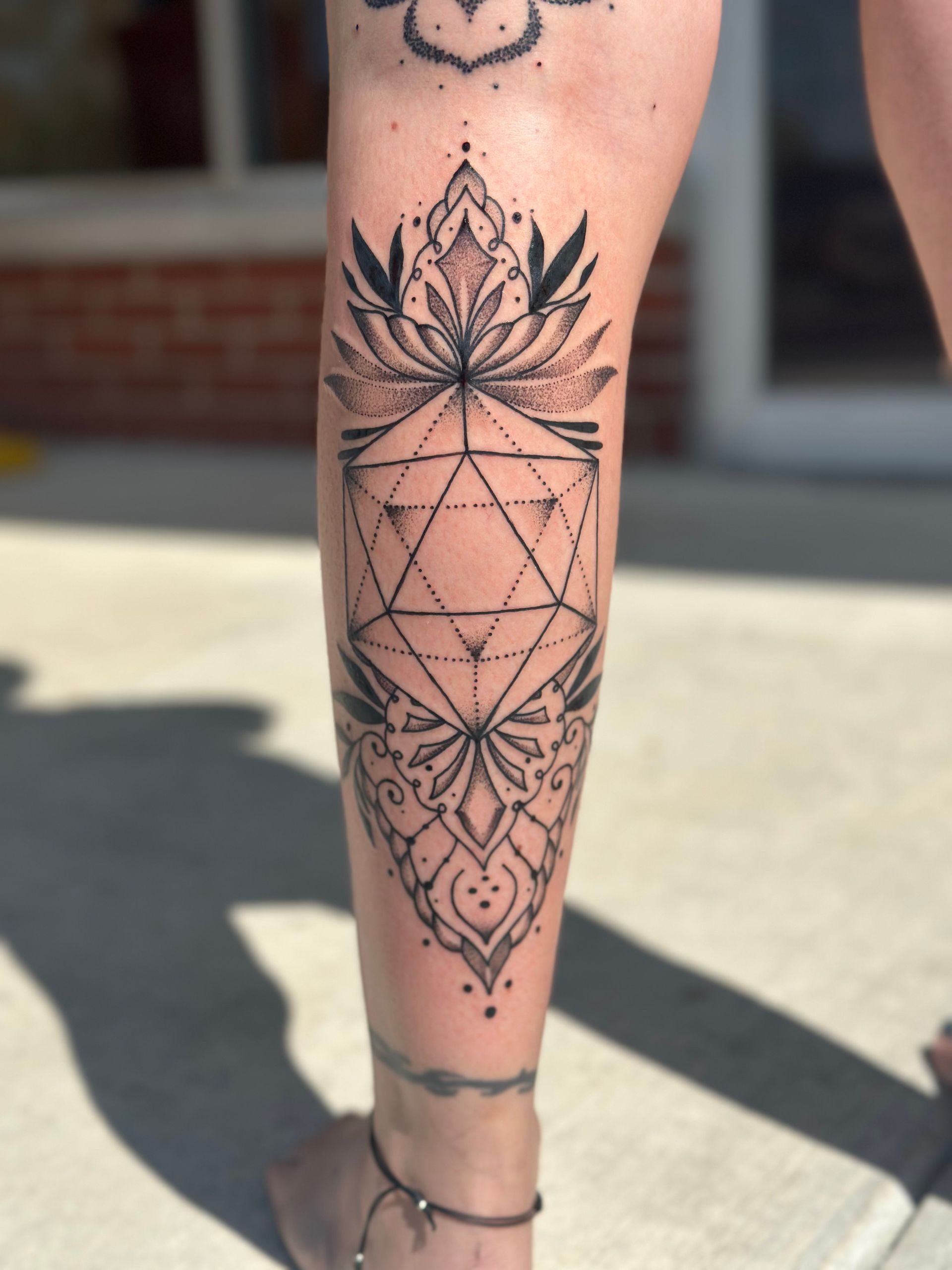 A woman has a geometric tattoo on her leg