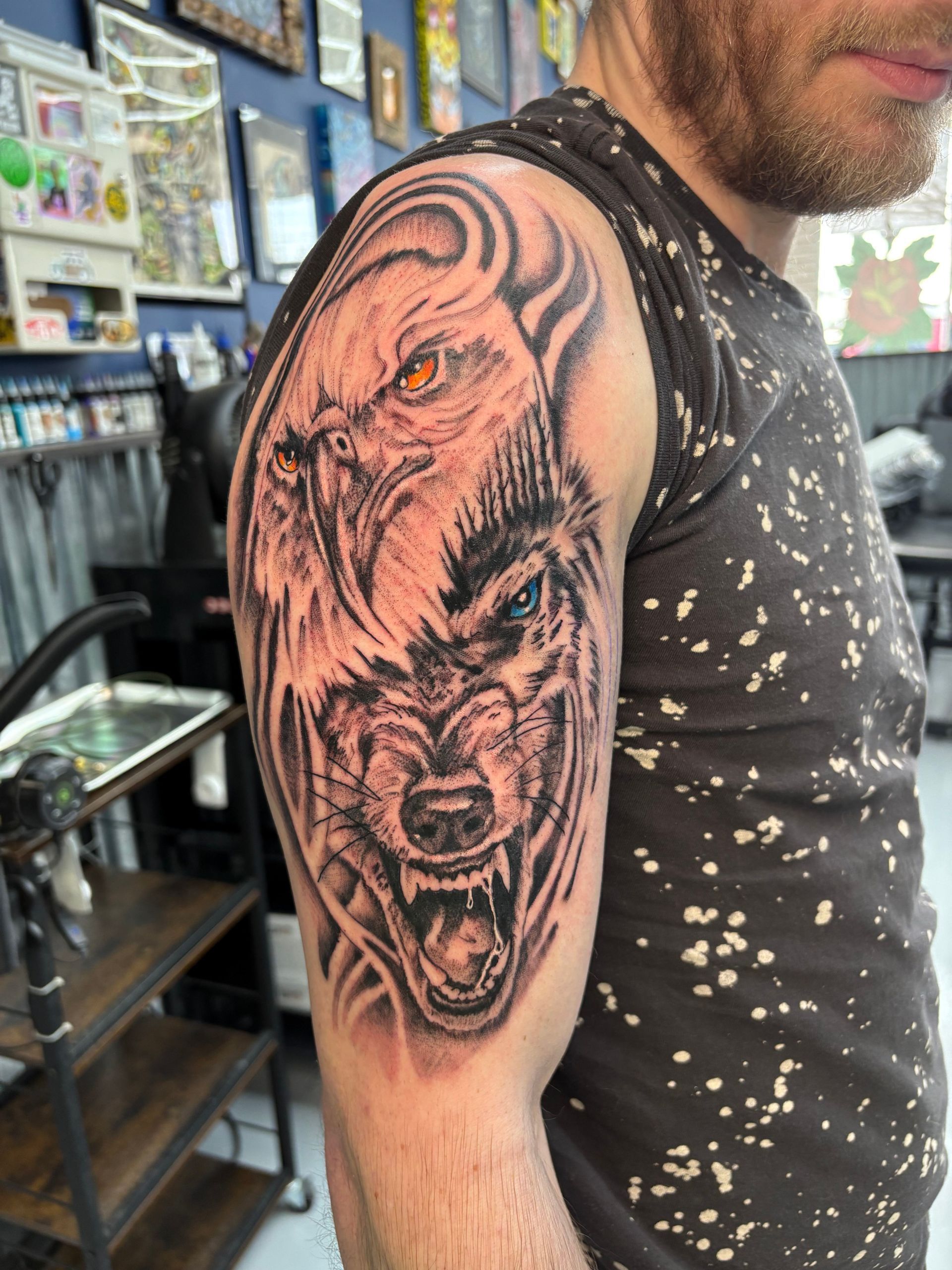 A man has a tattoo of a lion and a wolf on his arm