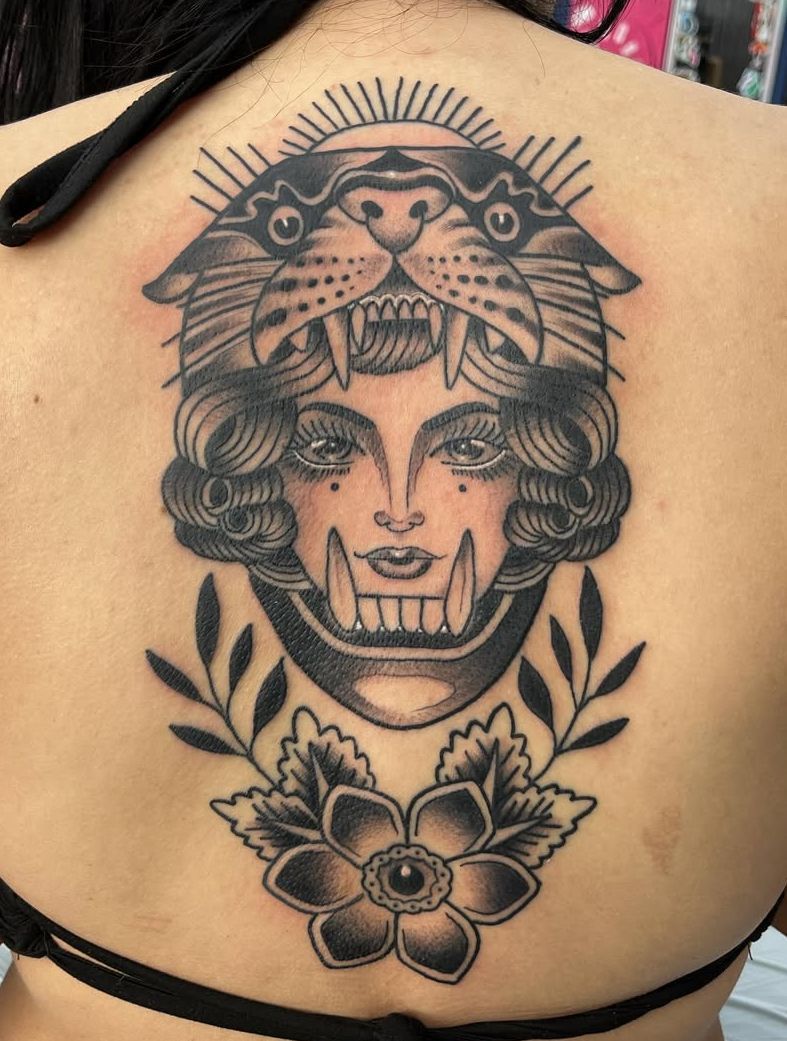 A woman has a tattoo of a woman with a tiger on her head