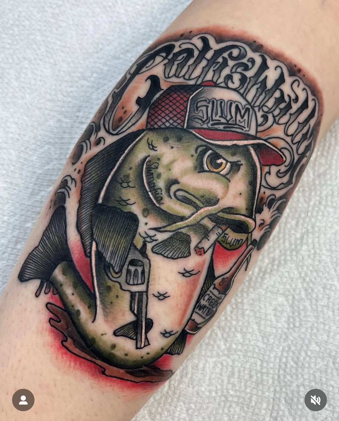 A tattoo of a fish holding a firearm
