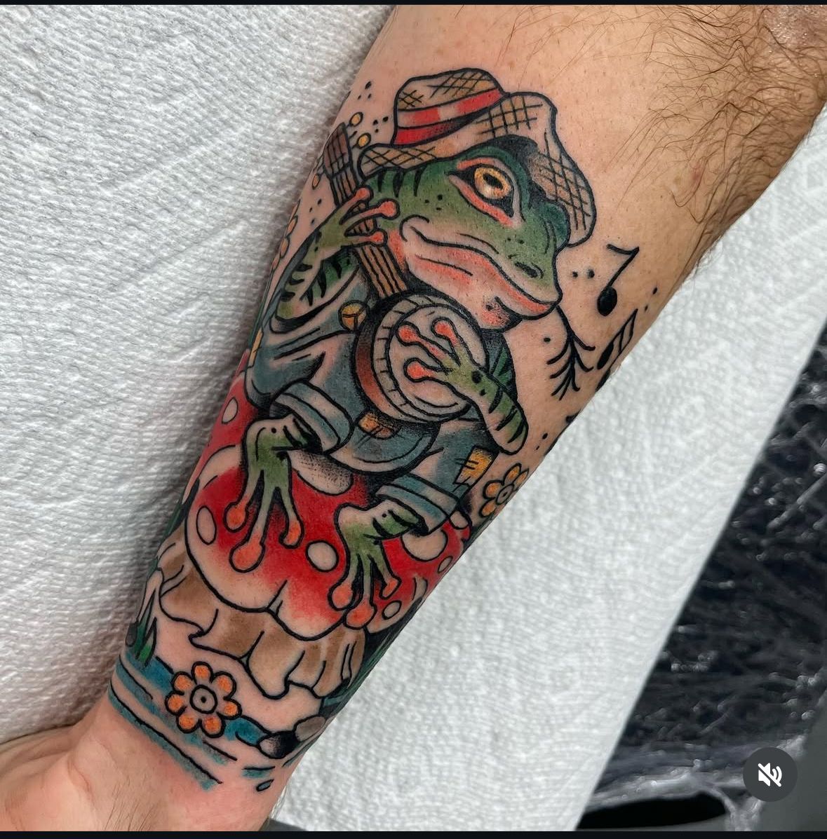A person has a tattoo of a frog on their forearm