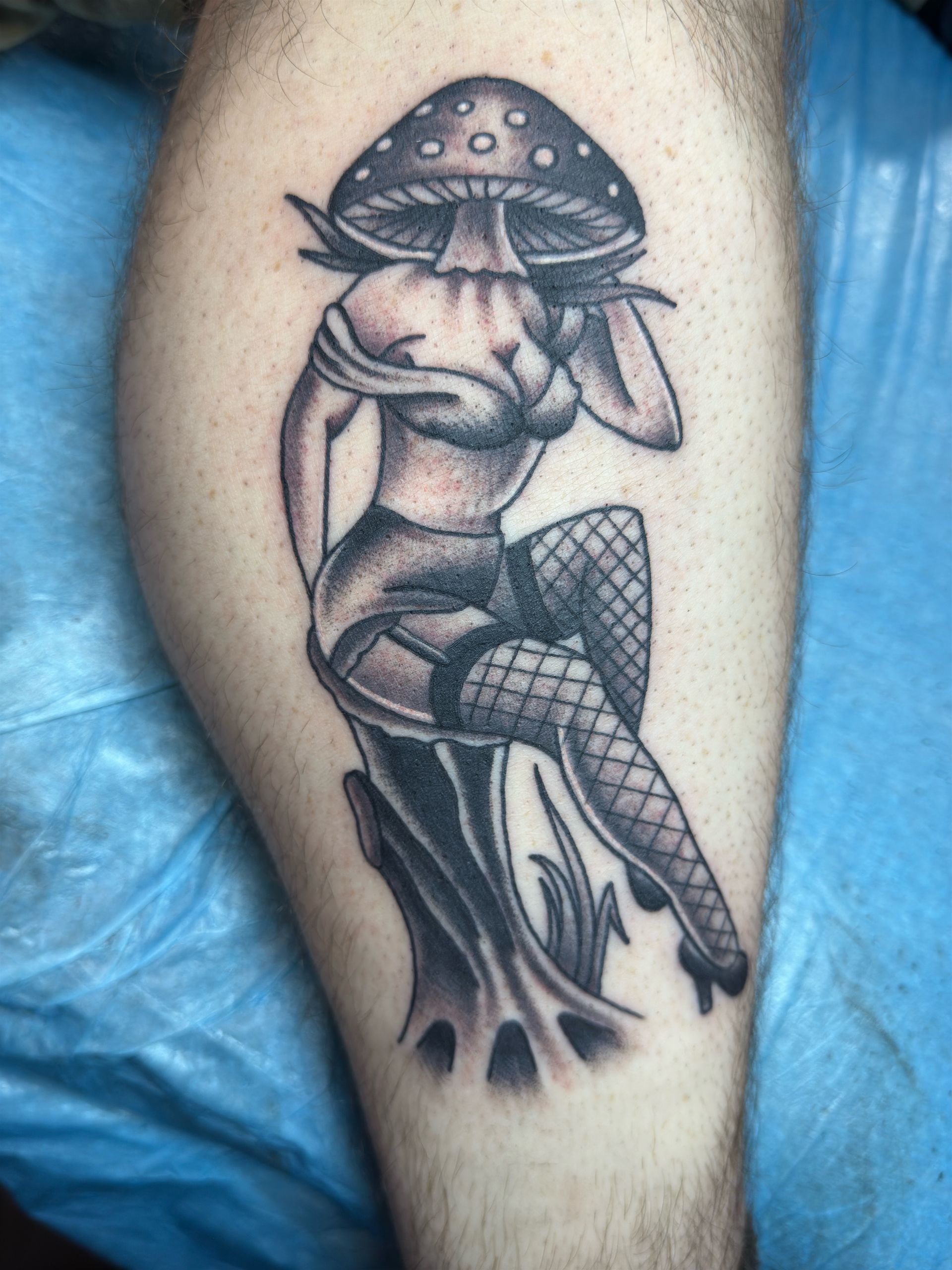 A tattoo of a woman with a mushroom on her head