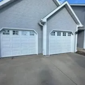 Garage interior with white sectional door open, construction in progress.