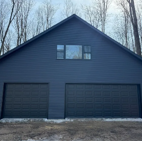 White garage door with shadows of tree branches and a concrete driveway.