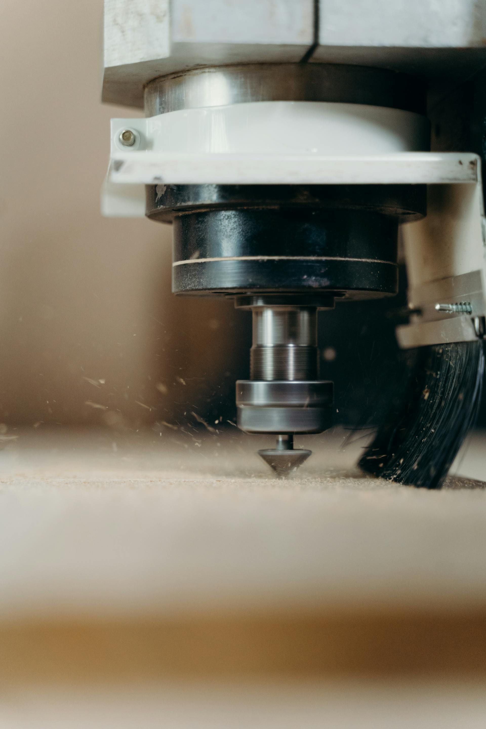 CNC machine cutting wood, close-up with visible cutter and wood shavings.
