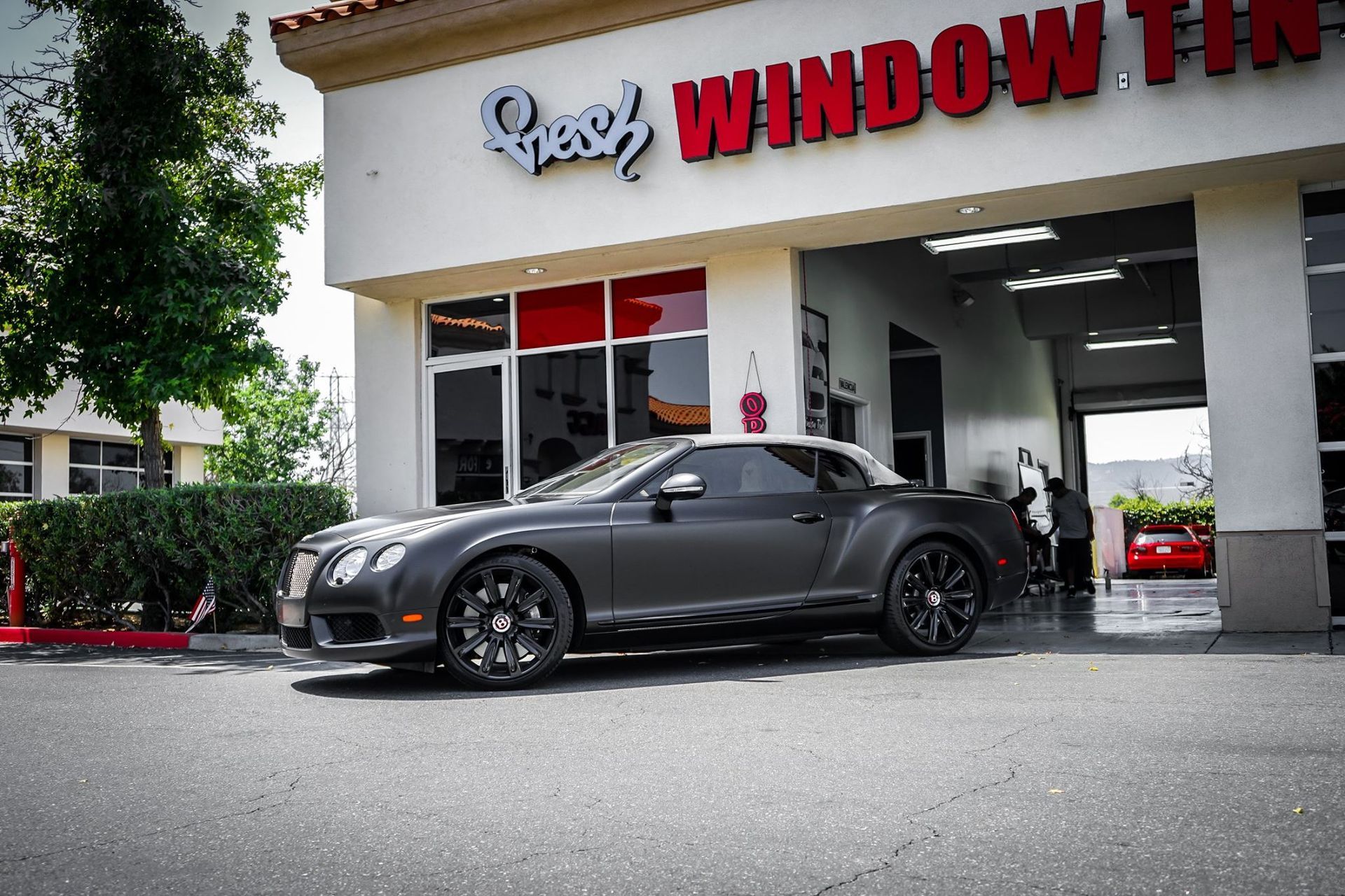 Gray Bentley convertible parked in front of 