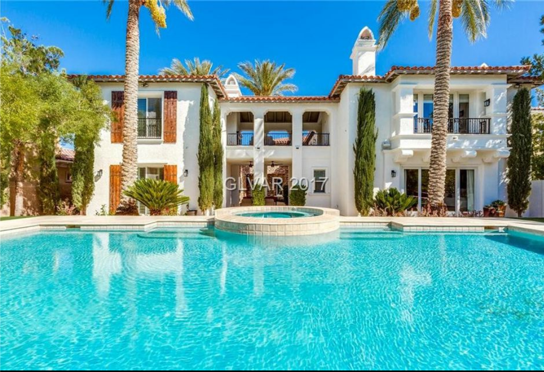 A large white house with a swimming pool in front of it