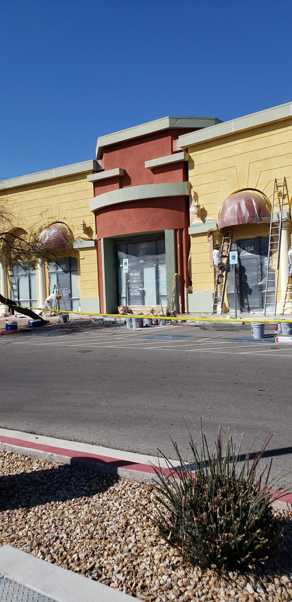 A large yellow and red building with a parking lot in front of it.