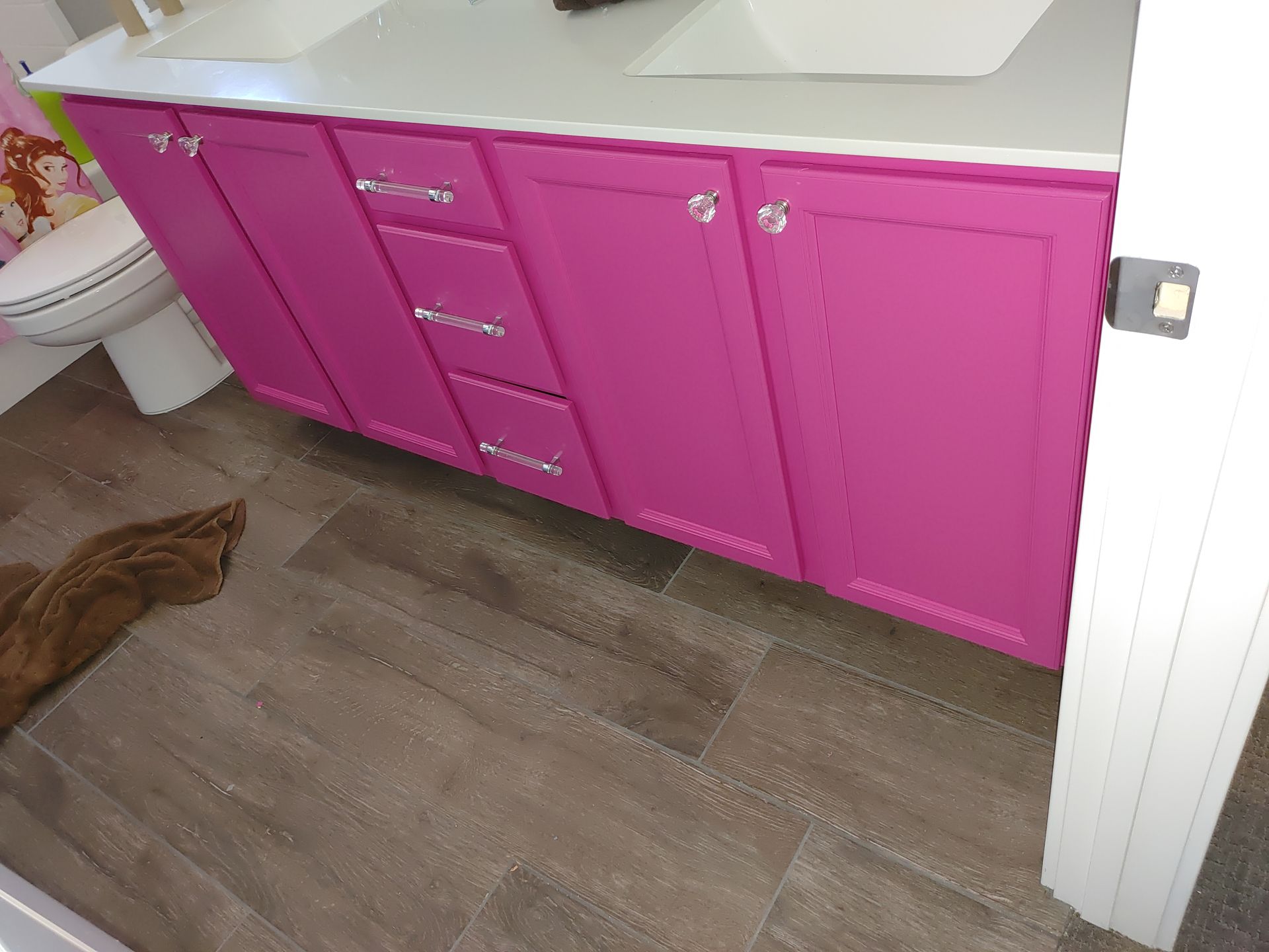 A bathroom with pink cabinets and a sink