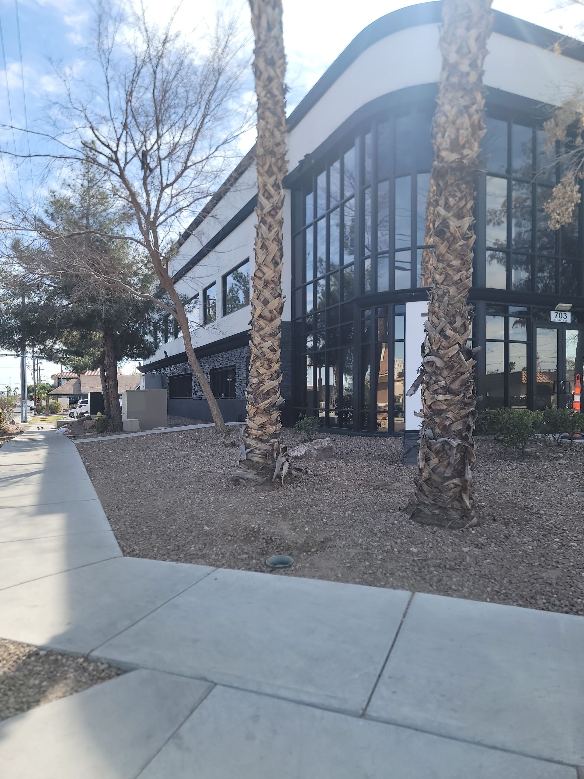 A large building with a lot of windows and palm trees in front of it