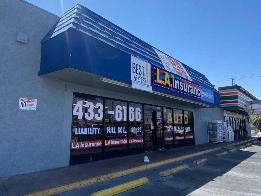 A store front with a blue awning and a 7 eleven in the background.