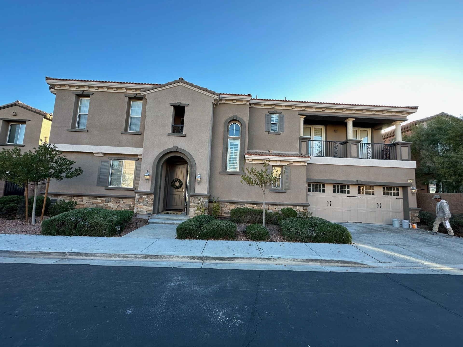 A large house with a man walking in front of it