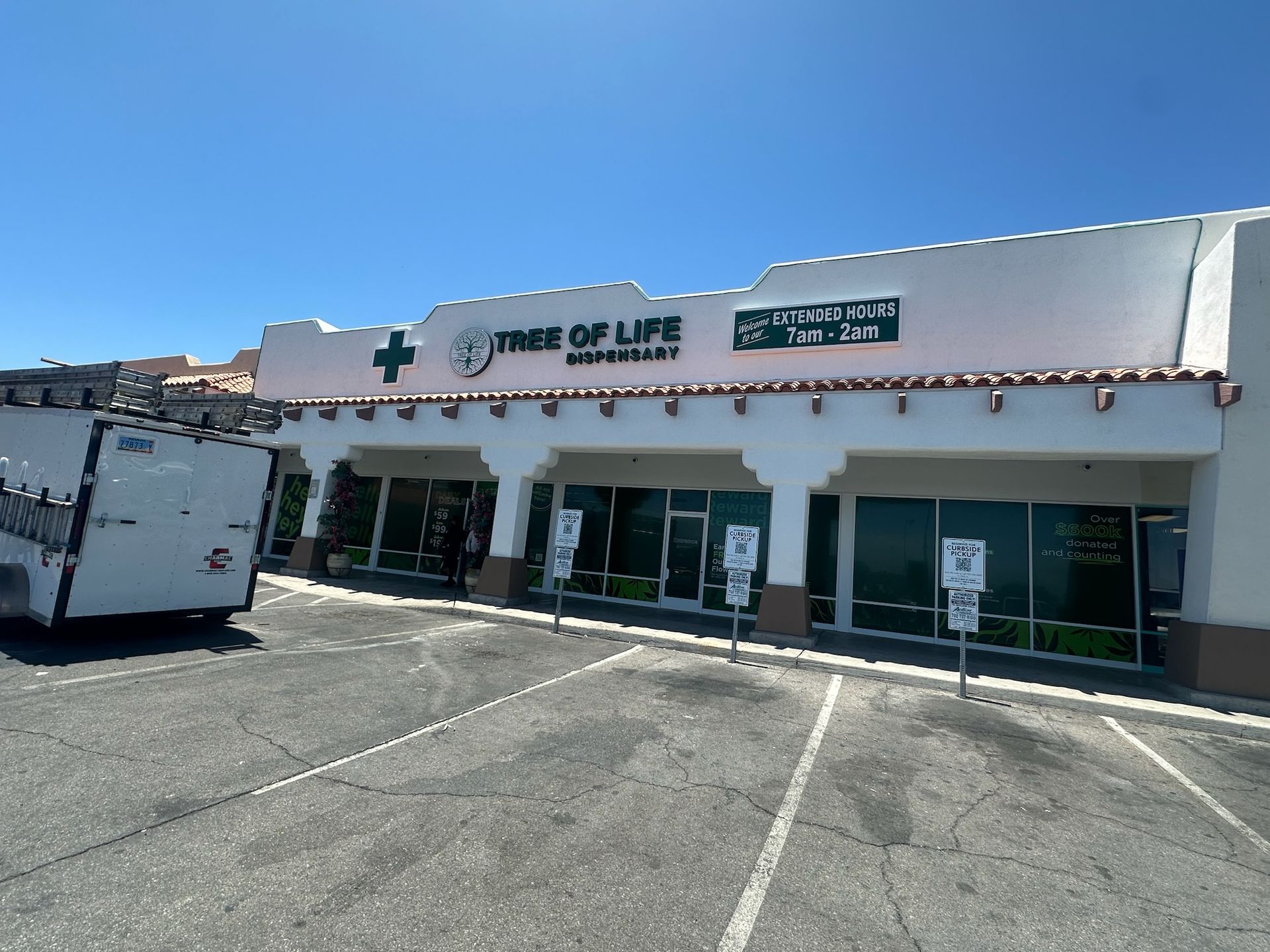 A white building with a green cross on the top of it