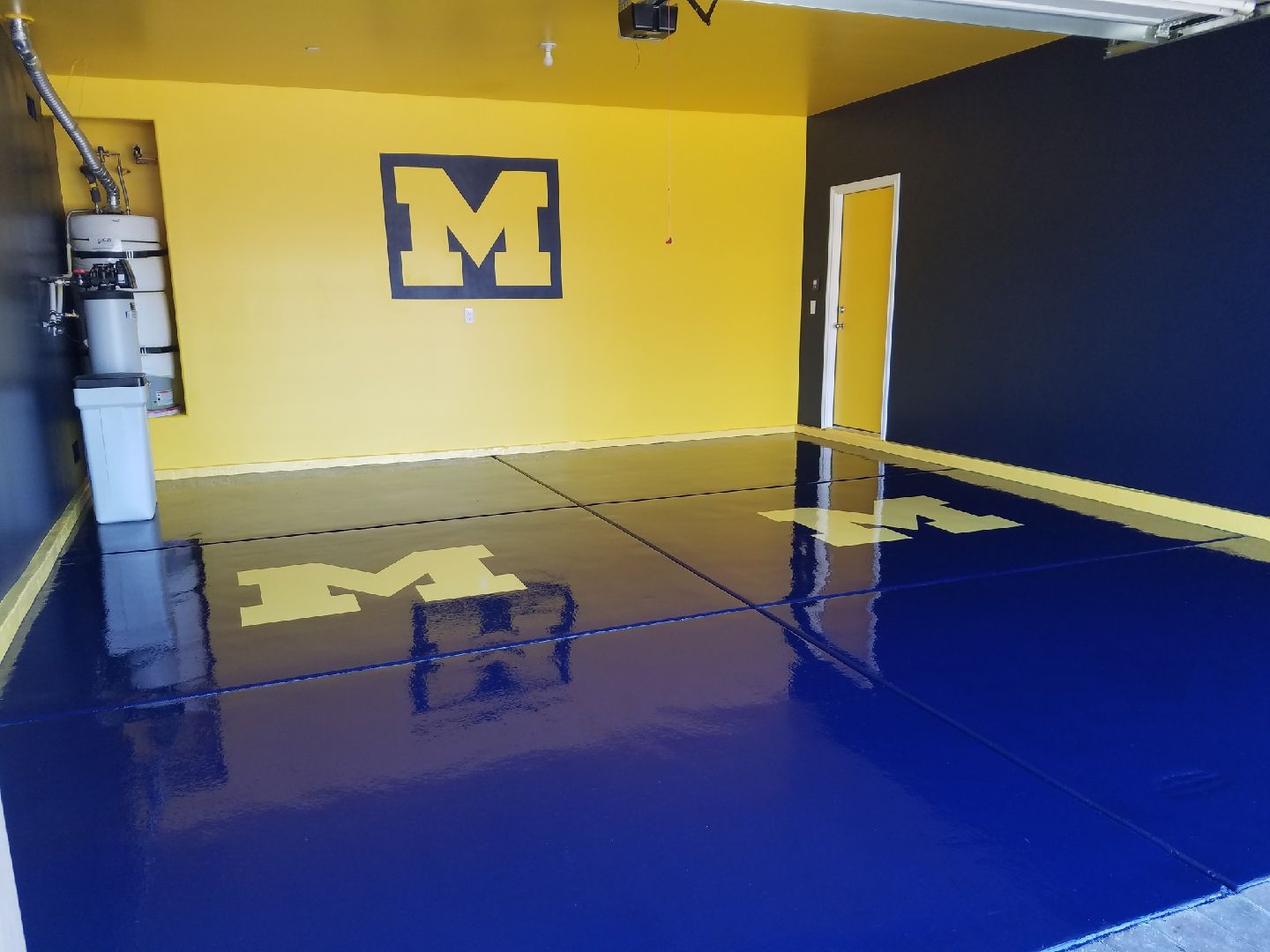 A blue and yellow garage with the letter m on the wall