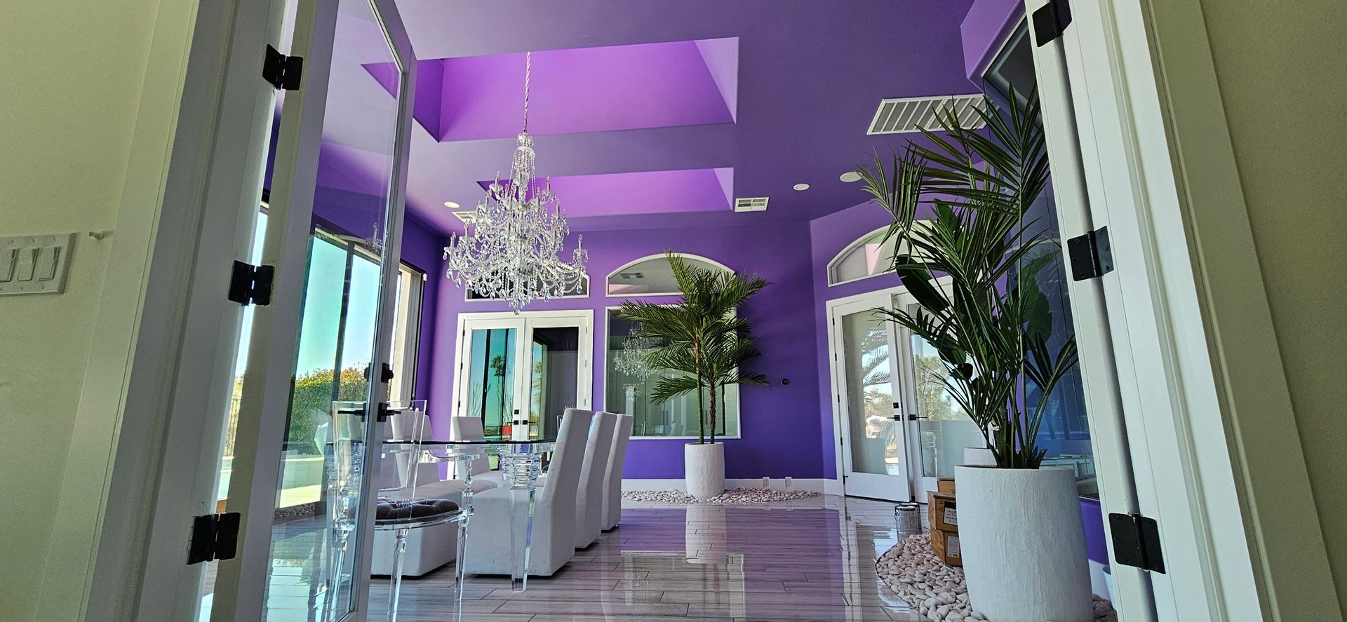 A living room with purple walls and a chandelier.