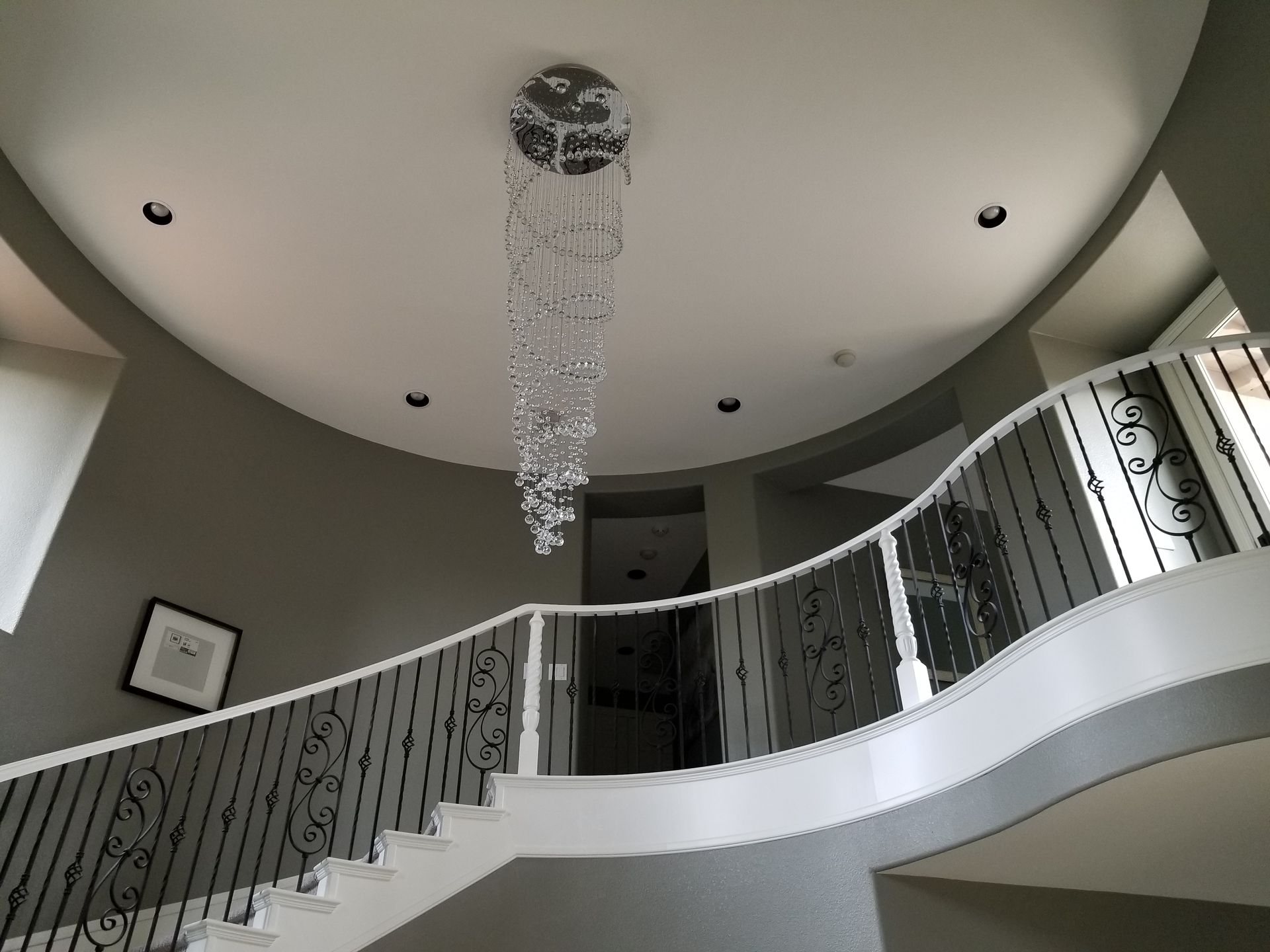 A staircase with a chandelier hanging from the ceiling